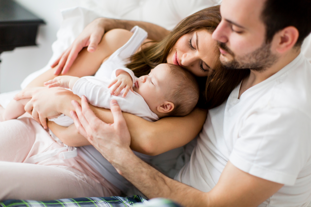 Young family holding their newborn baby in a peaceful moment at home